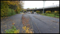 24.10.2020 - Der Rad/Gehweg ist bereits fertig asphaltiert. Zwischen den Stangen wird die Regenrinne mit Gussasphalt eingebaut. Westblick.